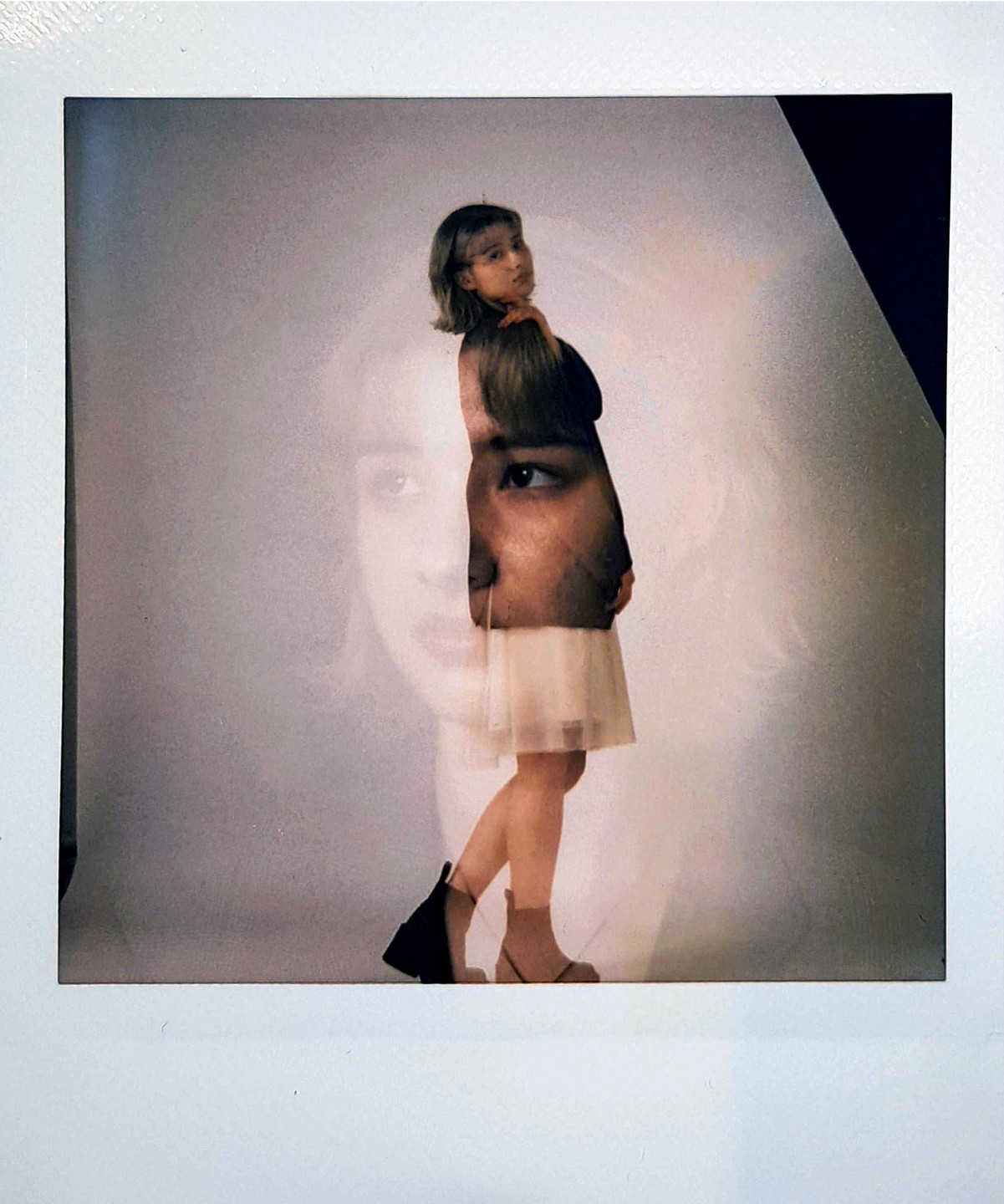 A woman stands in a studio with a double exposure of a face on her body.