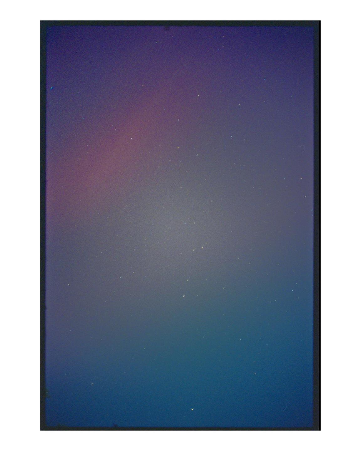 The night sky is filled with stars and a colorful aurora.