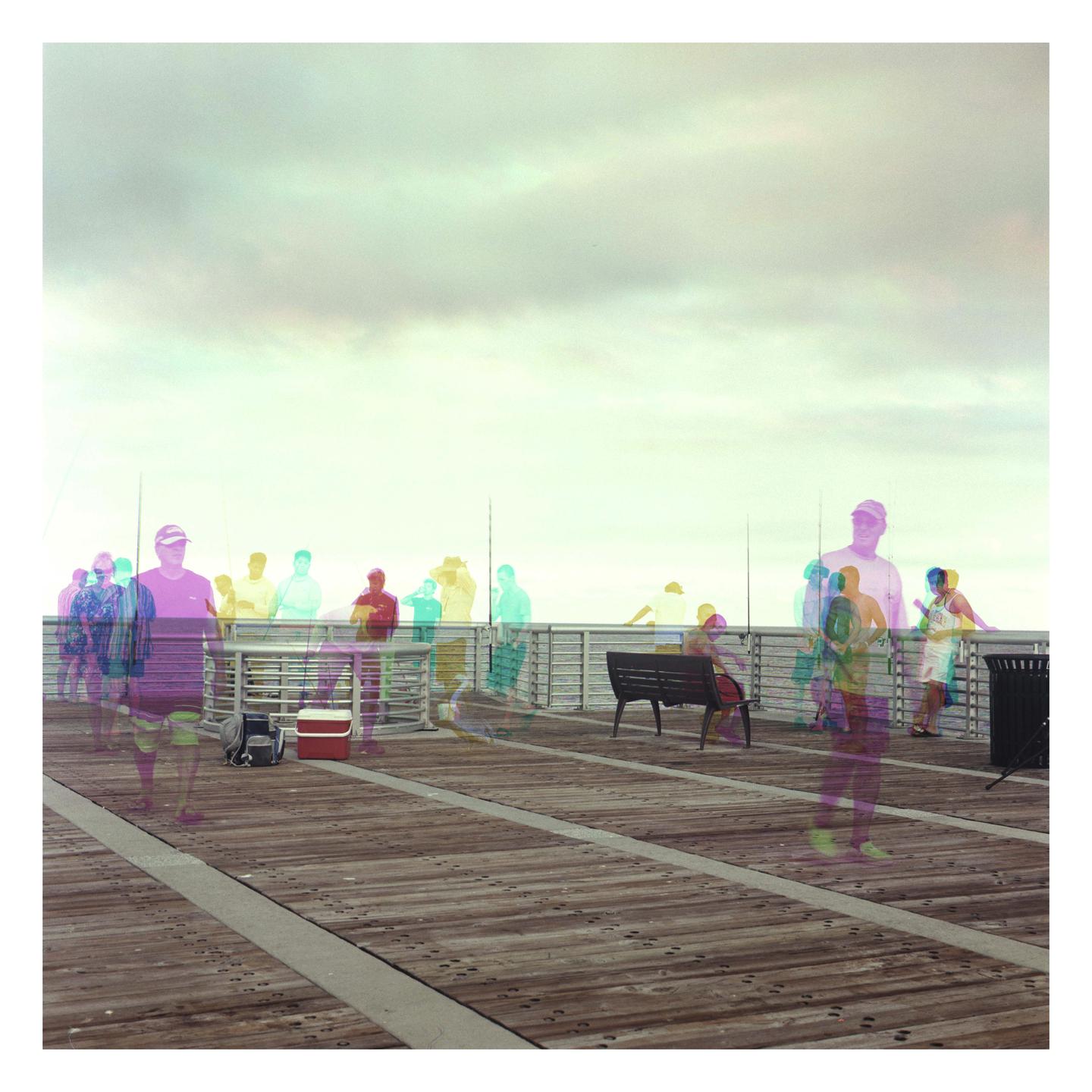 A group of people are visible on a pier under a cloudy sky, with some figures appearing as colorful, translucent overlays.