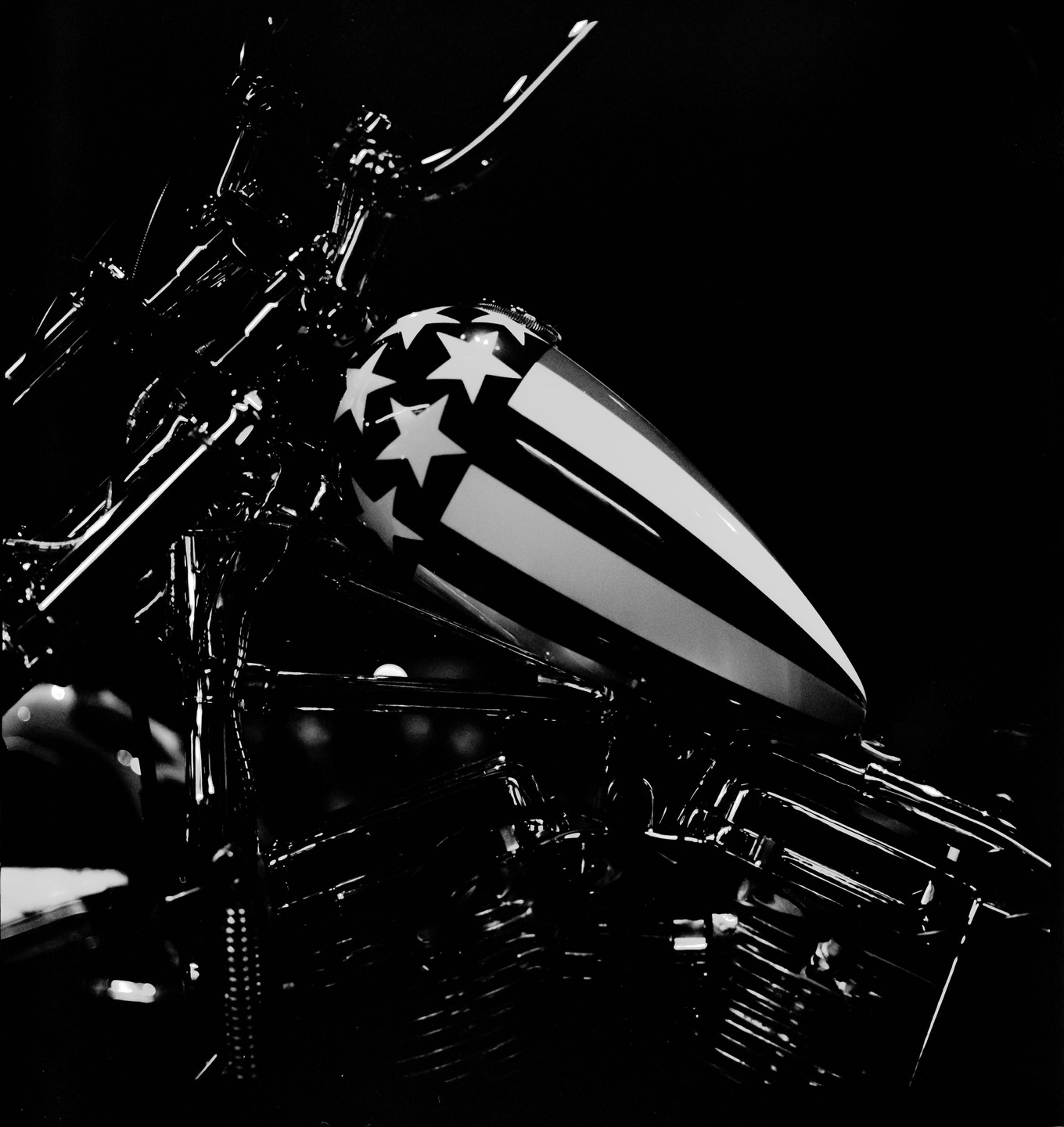 A motorcycle with an American flag-themed gas tank is shown in black and white.