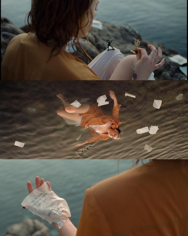 A woman interacts with toy soldiers on a rocky shore, floats in water surrounded by paper, and holds a crumpled piece of paper.