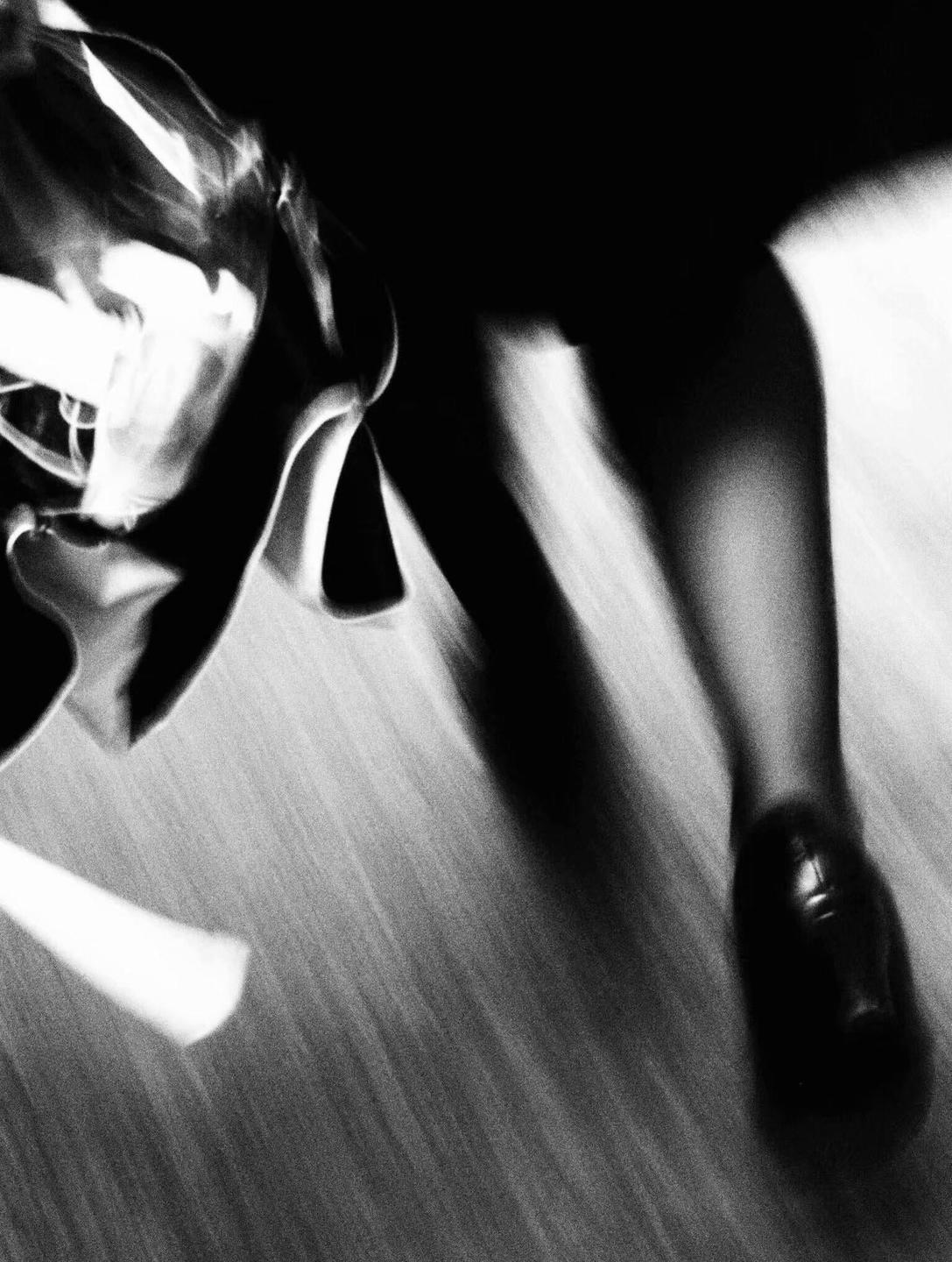 A person's leg and foot are visible in motion with a blurred background.