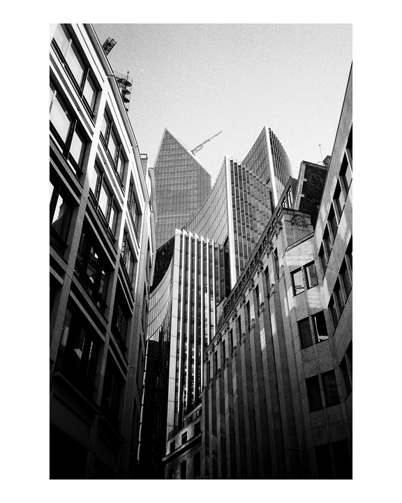 Modern and traditional buildings rise towards the sky, with a crane visible in the distance.