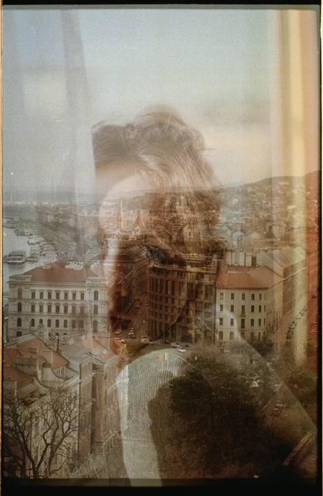 A double exposure shows a woman's head overlaid on a cityscape with buildings and a river.