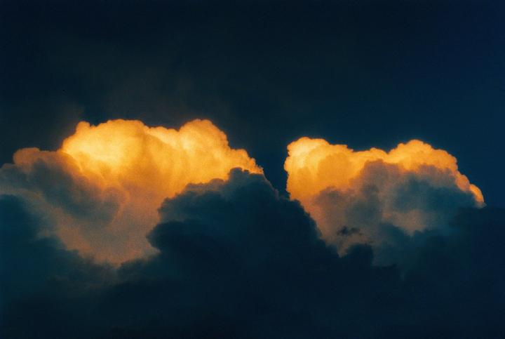 Two bright orange clouds are visible against a dark blue sky.