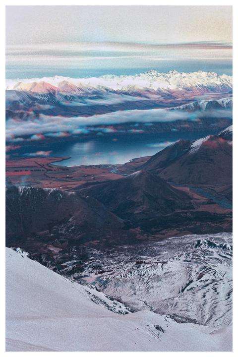 A vast mountain landscape with a lake and clouds is visible from a high vantage point.