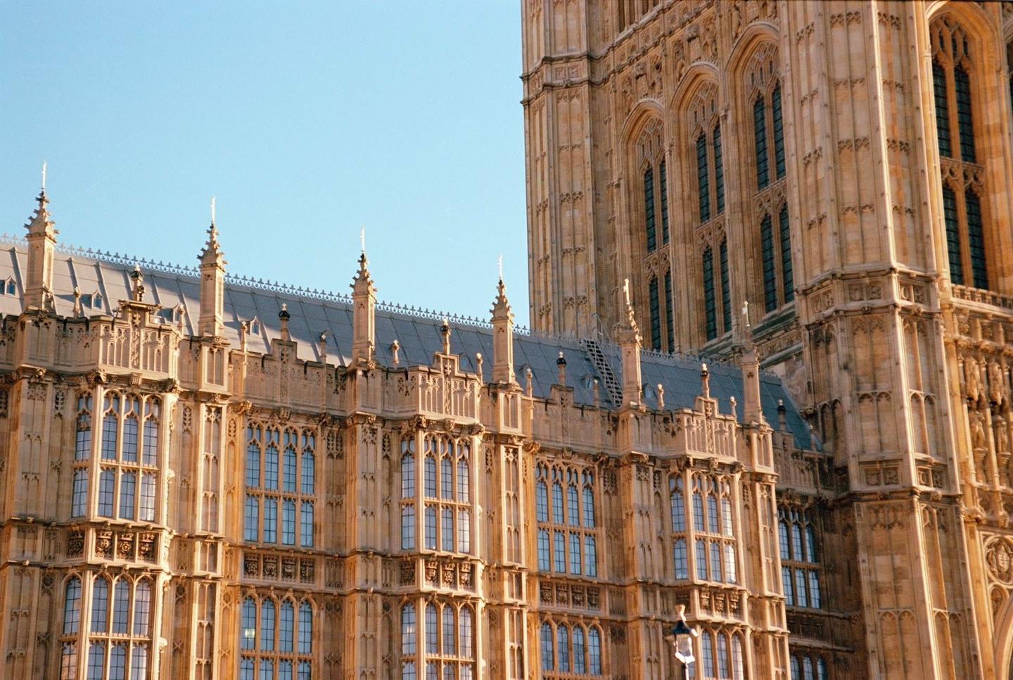 A detailed view of the Houses of Parliament shows its intricate architecture under a clear sky.