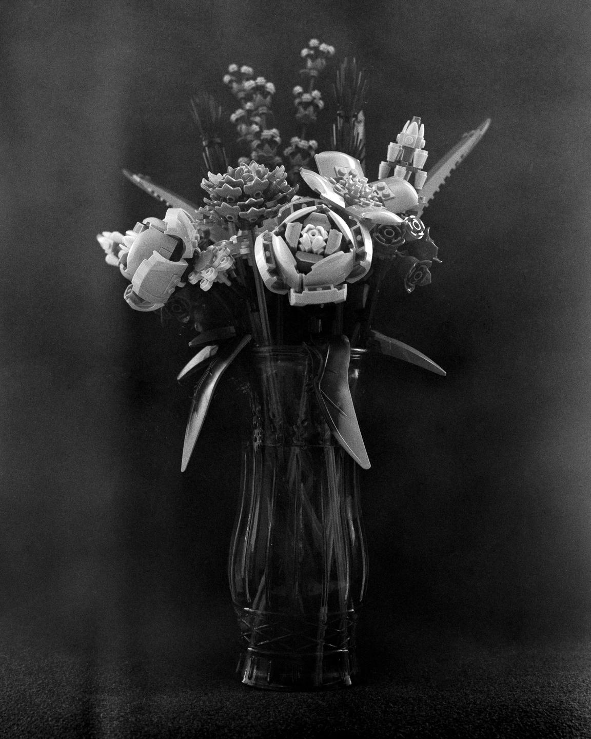 A bouquet of plastic flowers is arranged in a glass vase.
