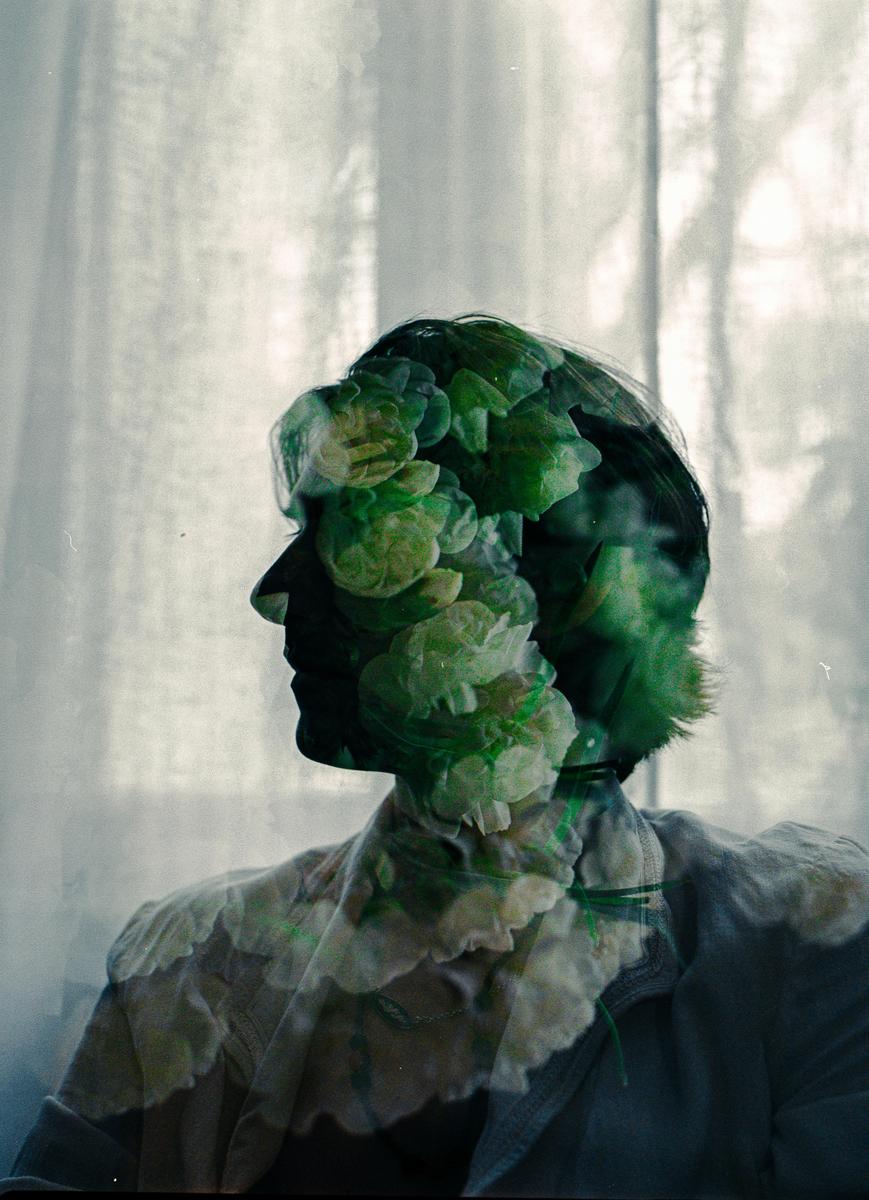 A double exposure shows a man in profile with flowers superimposed over his head and body.