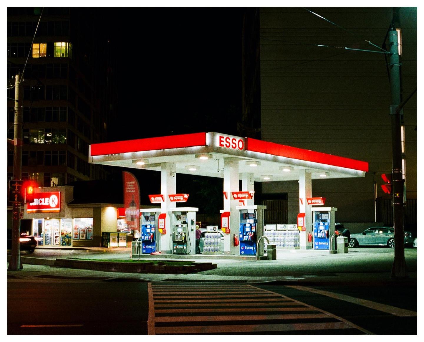 An Esso gas station and a Circle K convenience store are brightly lit at night.