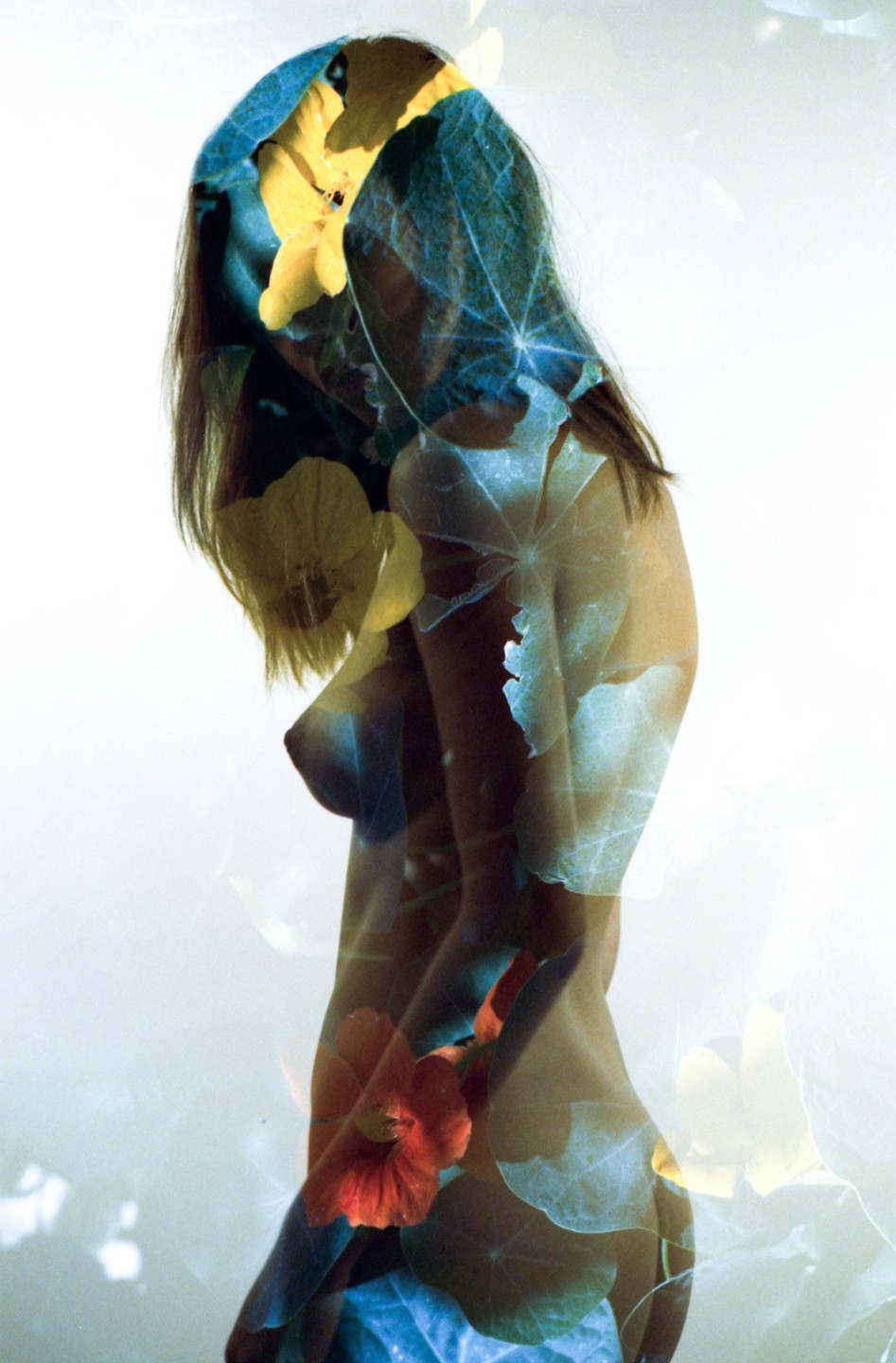A woman's body is overlaid with yellow and orange flowers and green leaves in a double exposure.