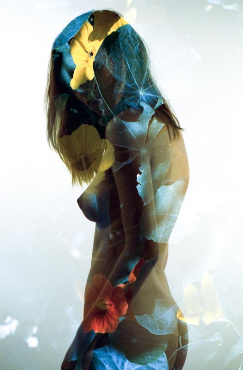 A woman's body is overlaid with yellow and orange flowers and green leaves in a double exposure.