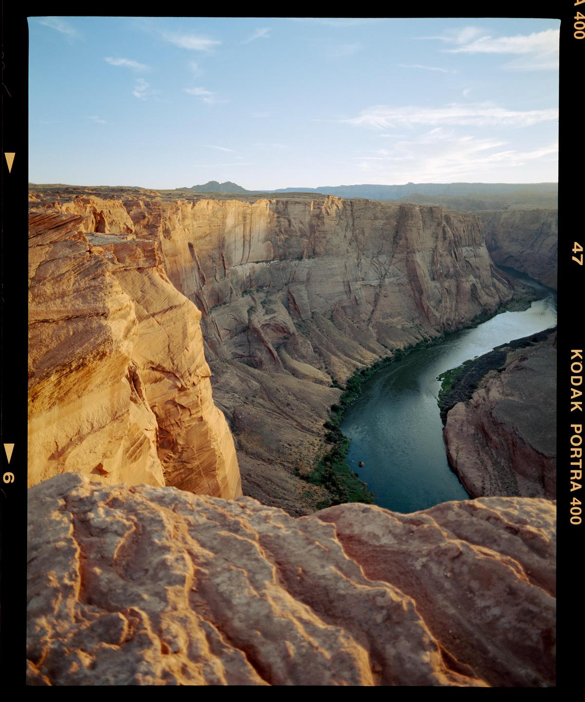 A river winds through a deep canyon with steep, rocky walls under a clear sky.