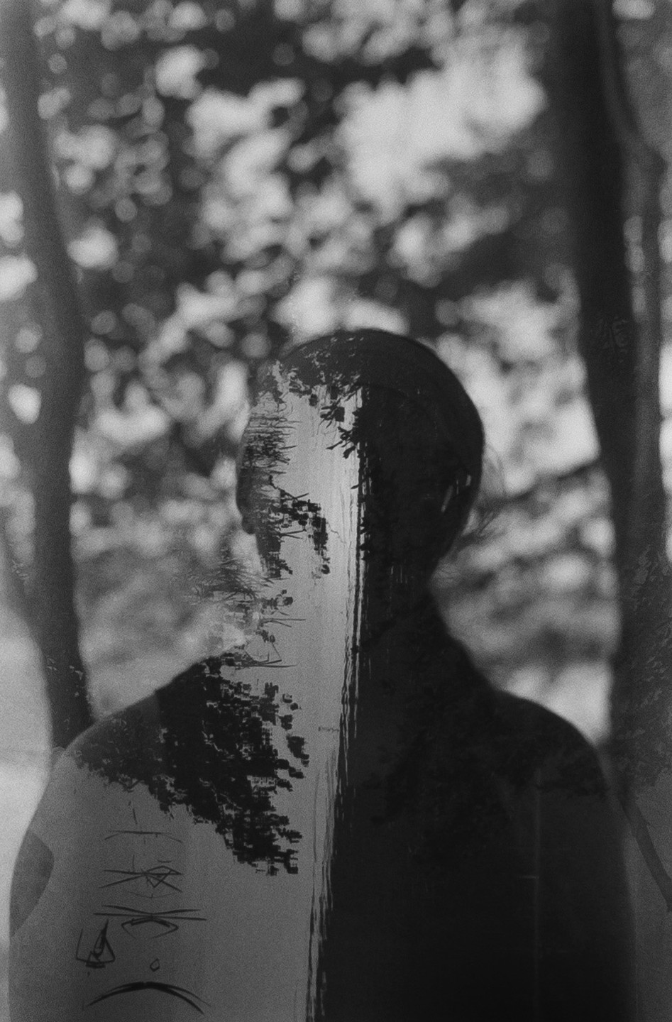 A double exposure shows a person's silhouette overlaid with a reflection of trees on water.