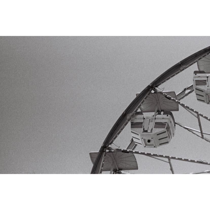 A ferris wheel with several gondolas is visible against a clear sky.