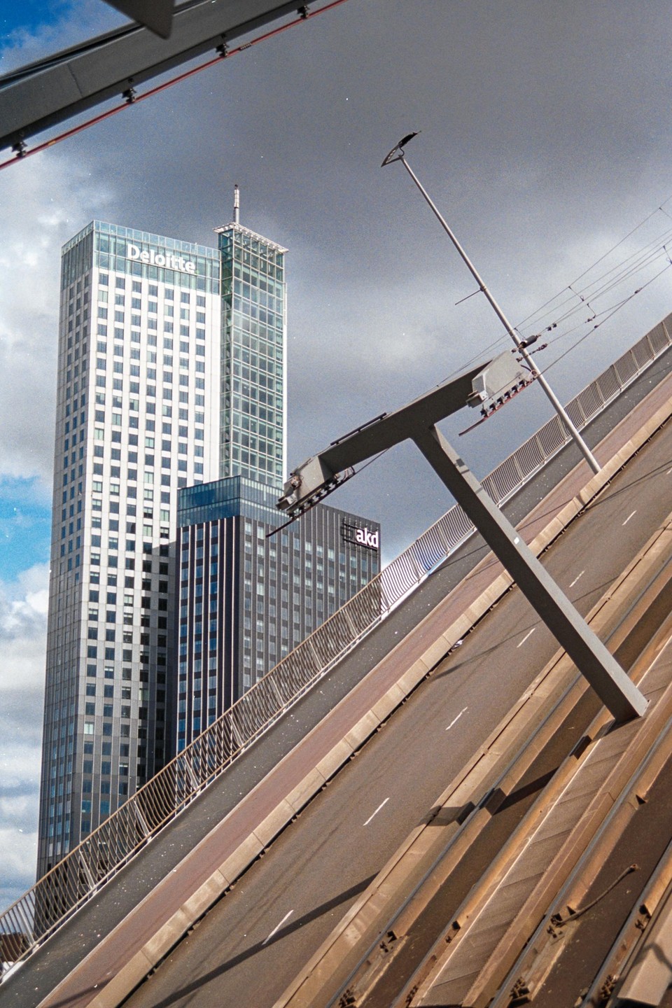 A tall building with a "Deloitte" sign stands behind a raised drawbridge.