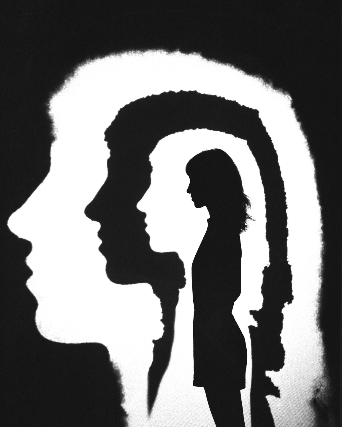 A woman's silhouette is framed by two larger silhouettes of faces in profile.