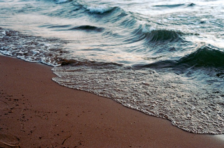 Waves crash onto a sandy beach.