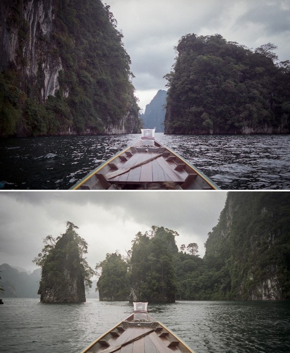 A boat travels through a narrow channel between two large, tree-covered rock formations in a body of water under a cloudy sky.
