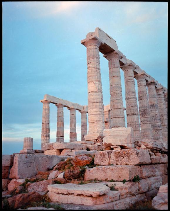 The Temple of Poseidon stands against a clear sky.
