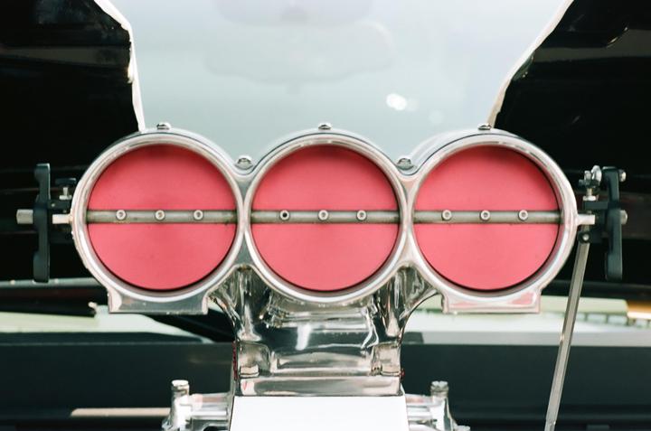 Three red and chrome air intakes are visible on a vehicle.
