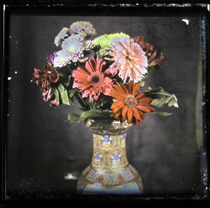 A colorful bouquet of flowers is arranged in an ornate vase.