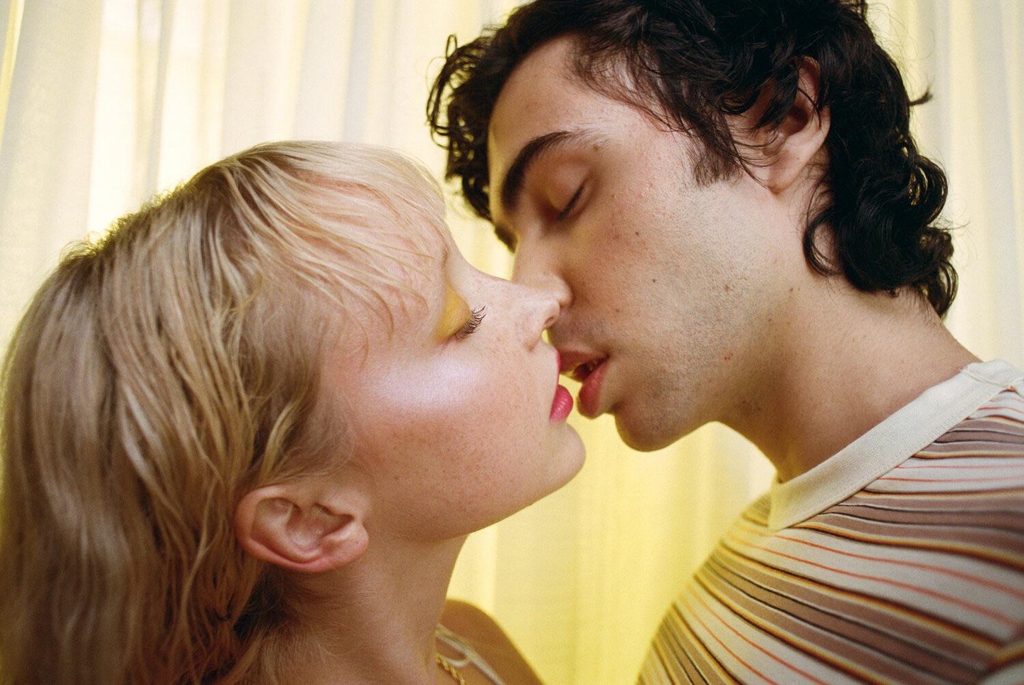 A man and a woman are about to kiss, with their faces close together.