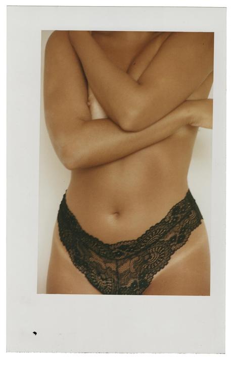A woman with crossed arms wears black lace underwear.