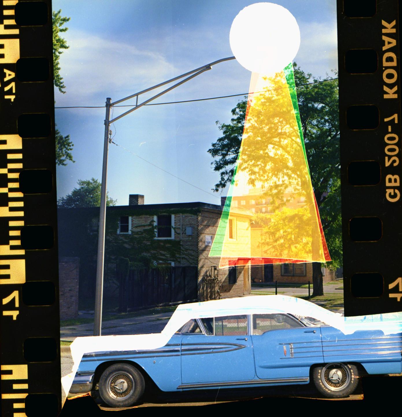 A blue vintage car is parked on a street with a building and trees in the background, overlaid with a white circle and colored triangles.