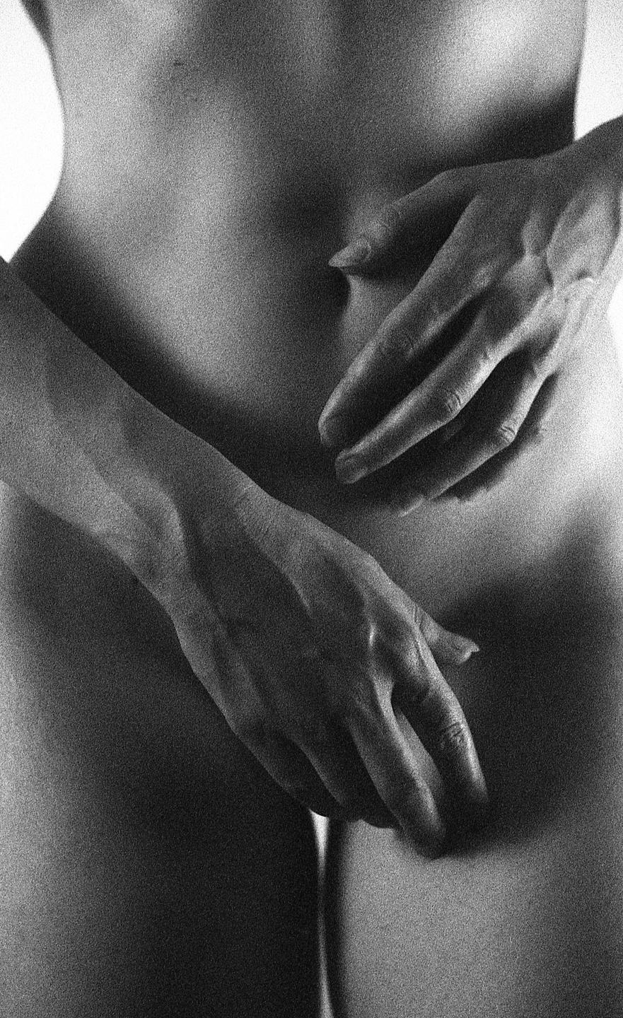 A person's torso and hands are visible in a black and white close-up.