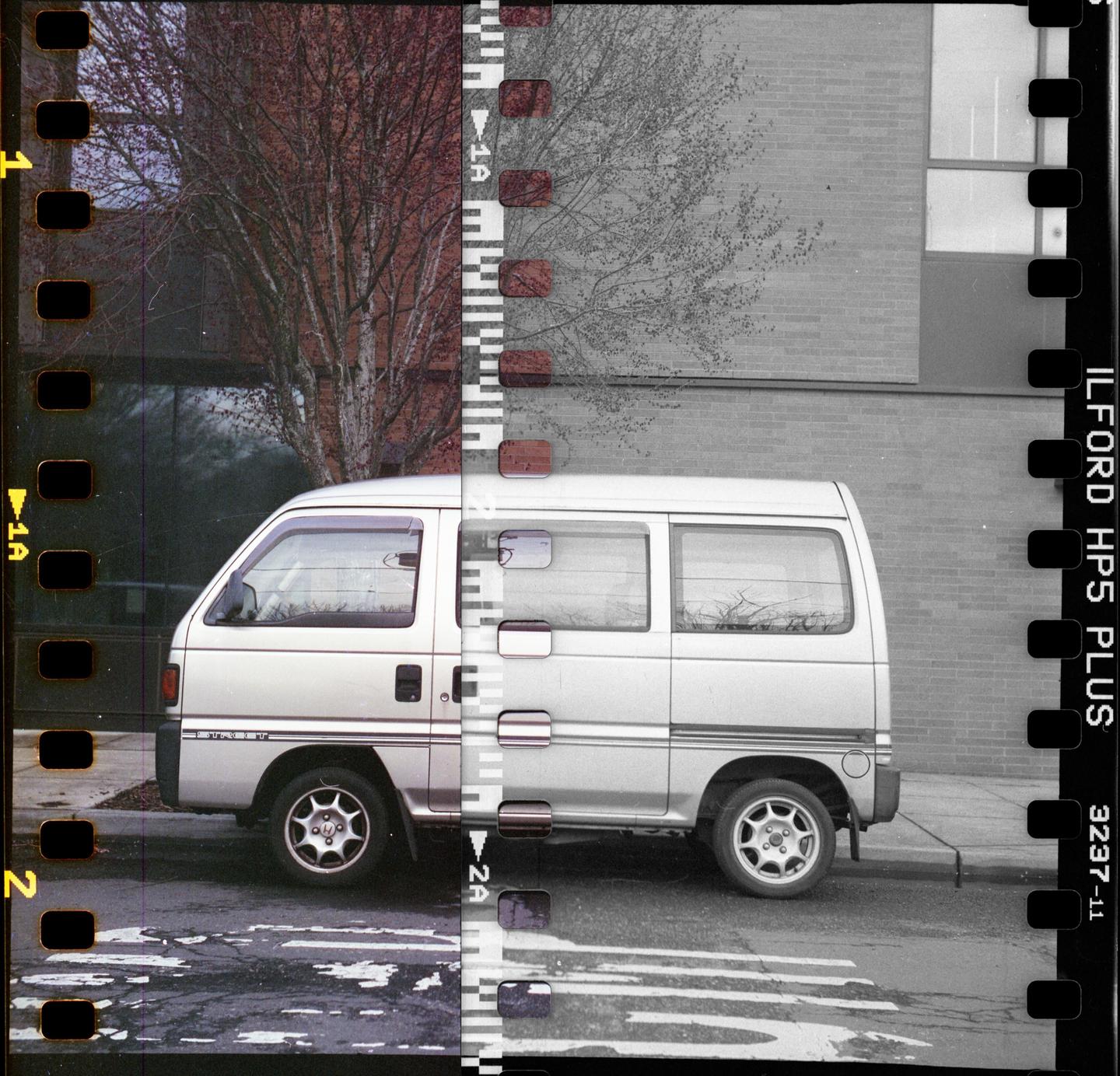 A silver van is parked on a street next to a building and a tree, with the image split between color and monochrome.