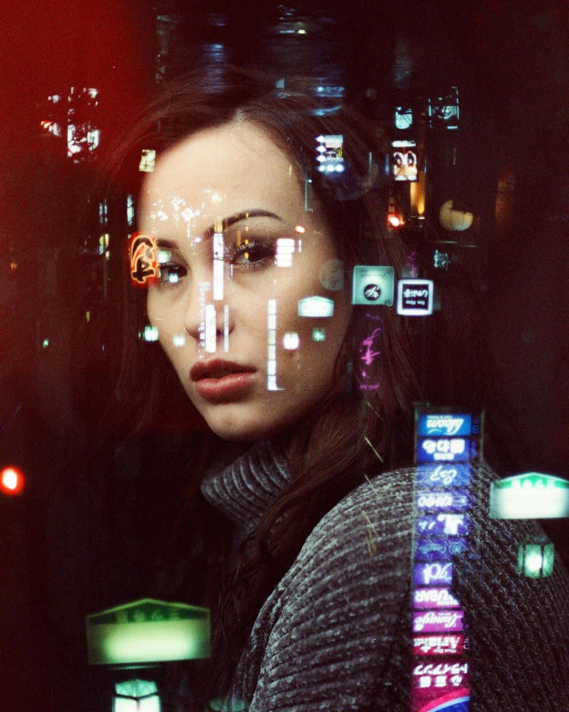 A woman with long hair and a turtleneck sweater looks to the side, with neon lights reflected on her face and body.