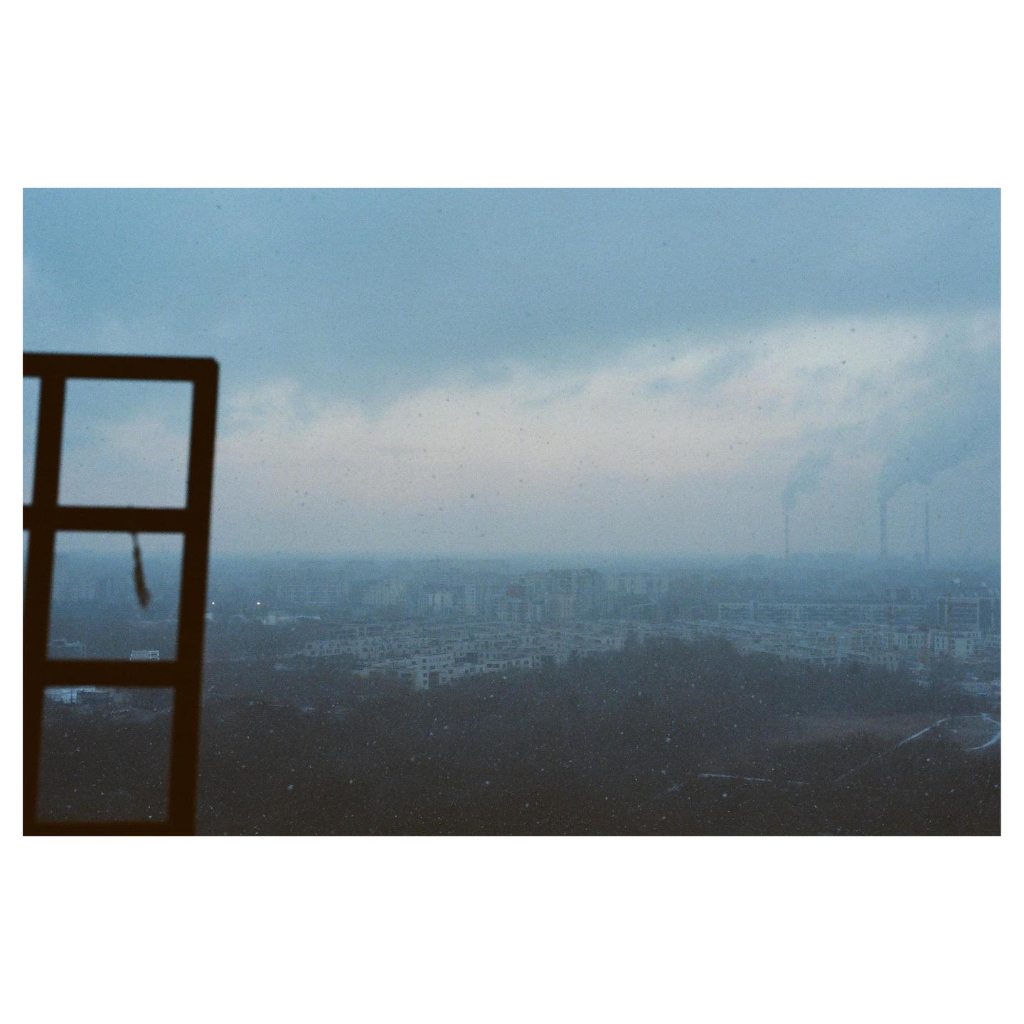 A city skyline is visible through a window on a hazy winter day.