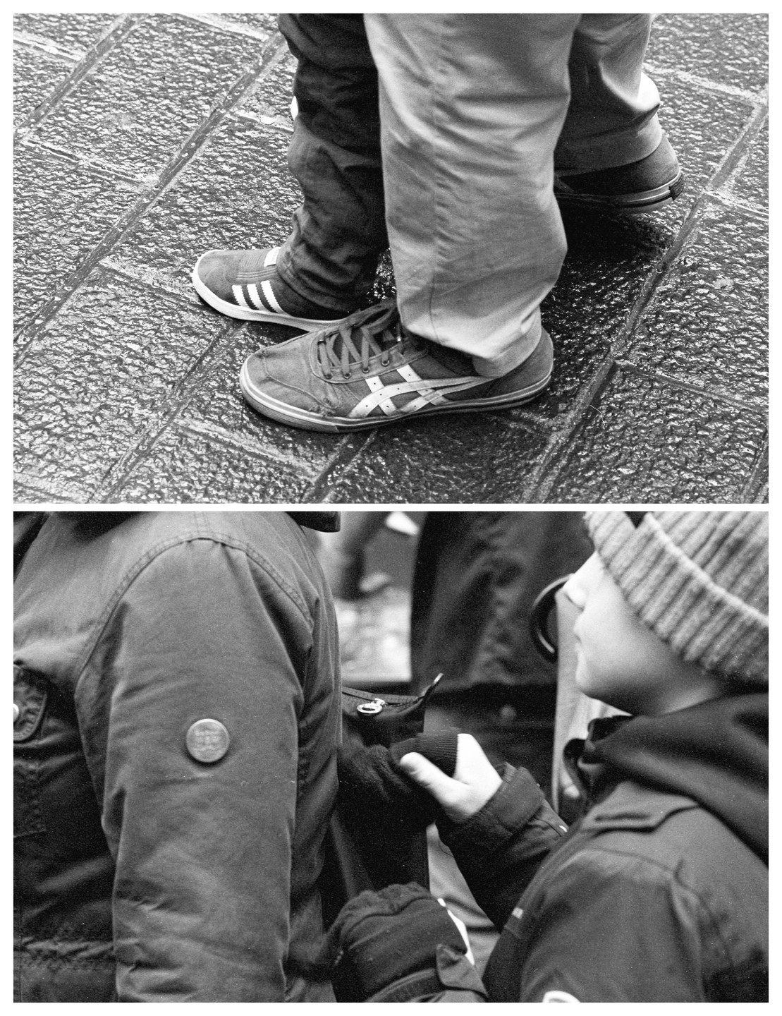 A child stands next to an adult, holding onto their arm, with a close-up of their feet on wet pavement below.