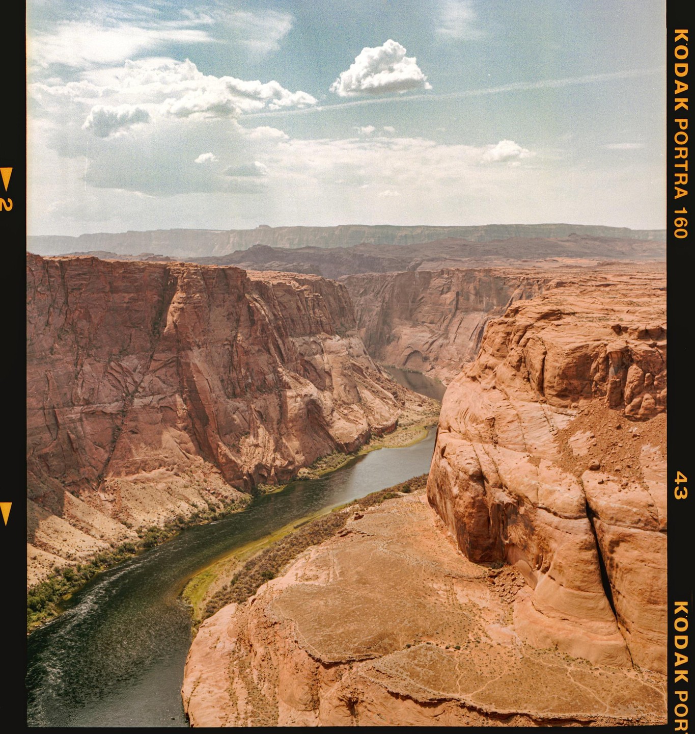 A river winds through a deep canyon under a cloudy sky.