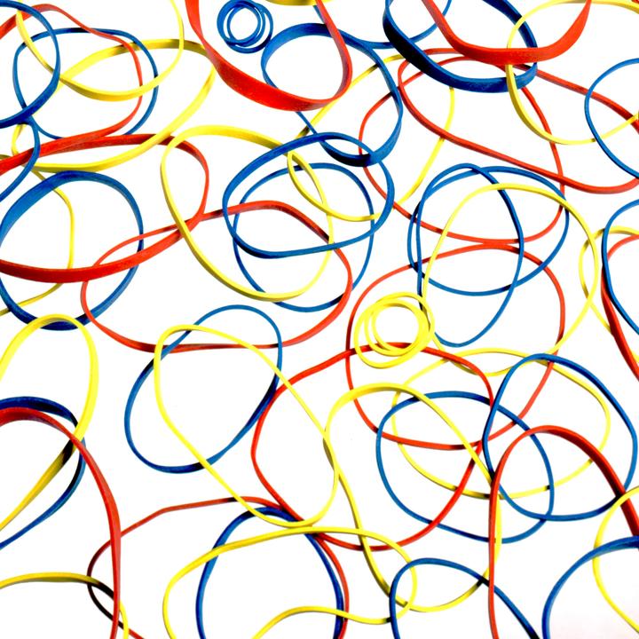 A white surface is covered with red, yellow, and blue rubber bands.