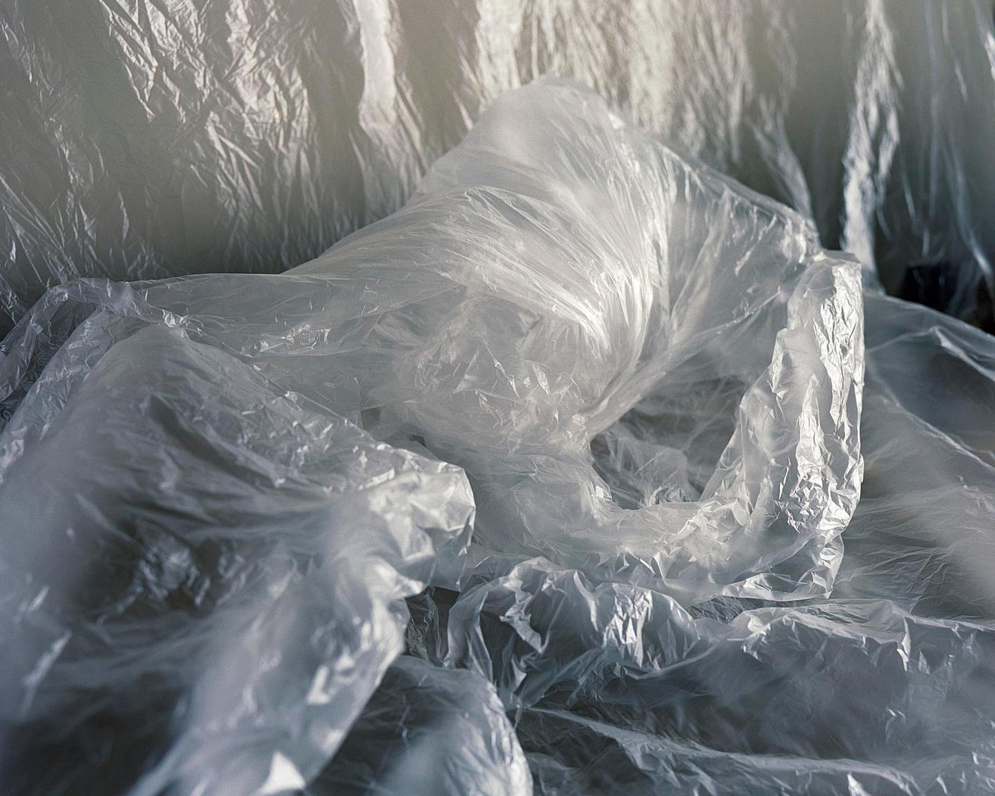 A close-up shot shows a pile of crumpled, translucent plastic bags.