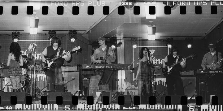 A band performs on stage with multiple exposures creating a layered effect.