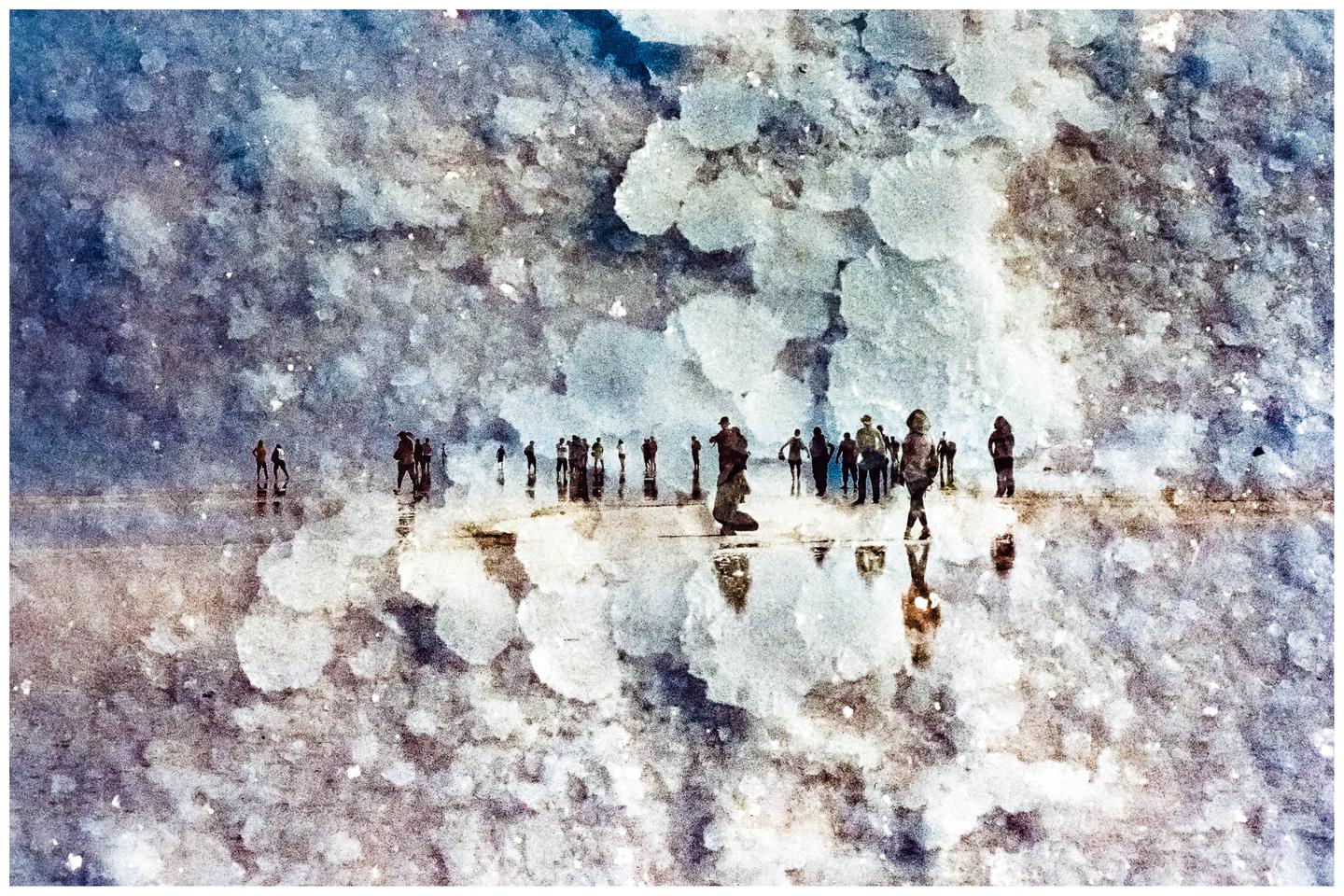 A group of people stand on a reflective surface under a textured sky.