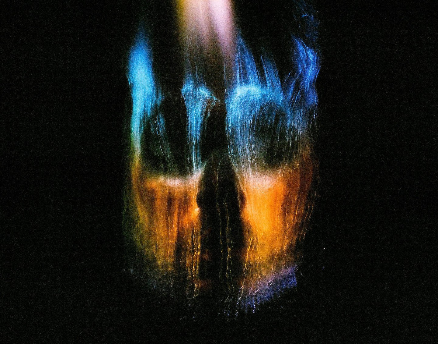 Abstract light streaks of blue and orange appear against a dark background.