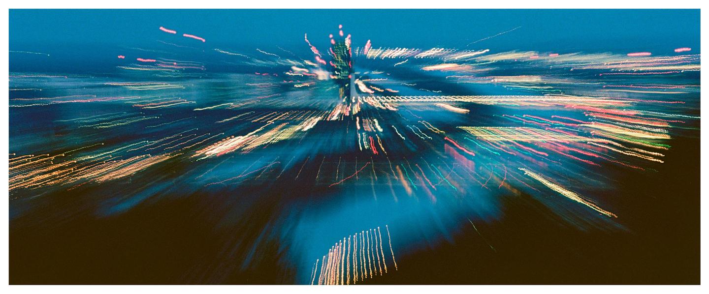 Streaks of colorful light radiate from the center of the frame against a dark background.
