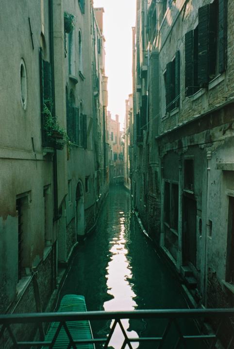 A narrow canal with buildings on both sides is visible from a bridge.