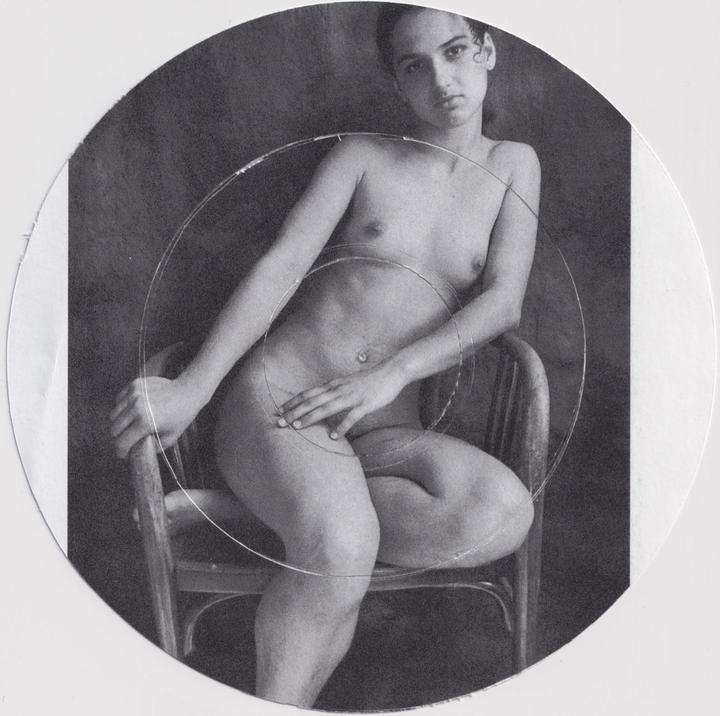 A nude woman sits on a wooden chair with her hand resting on her thigh, framed by two concentric circles.