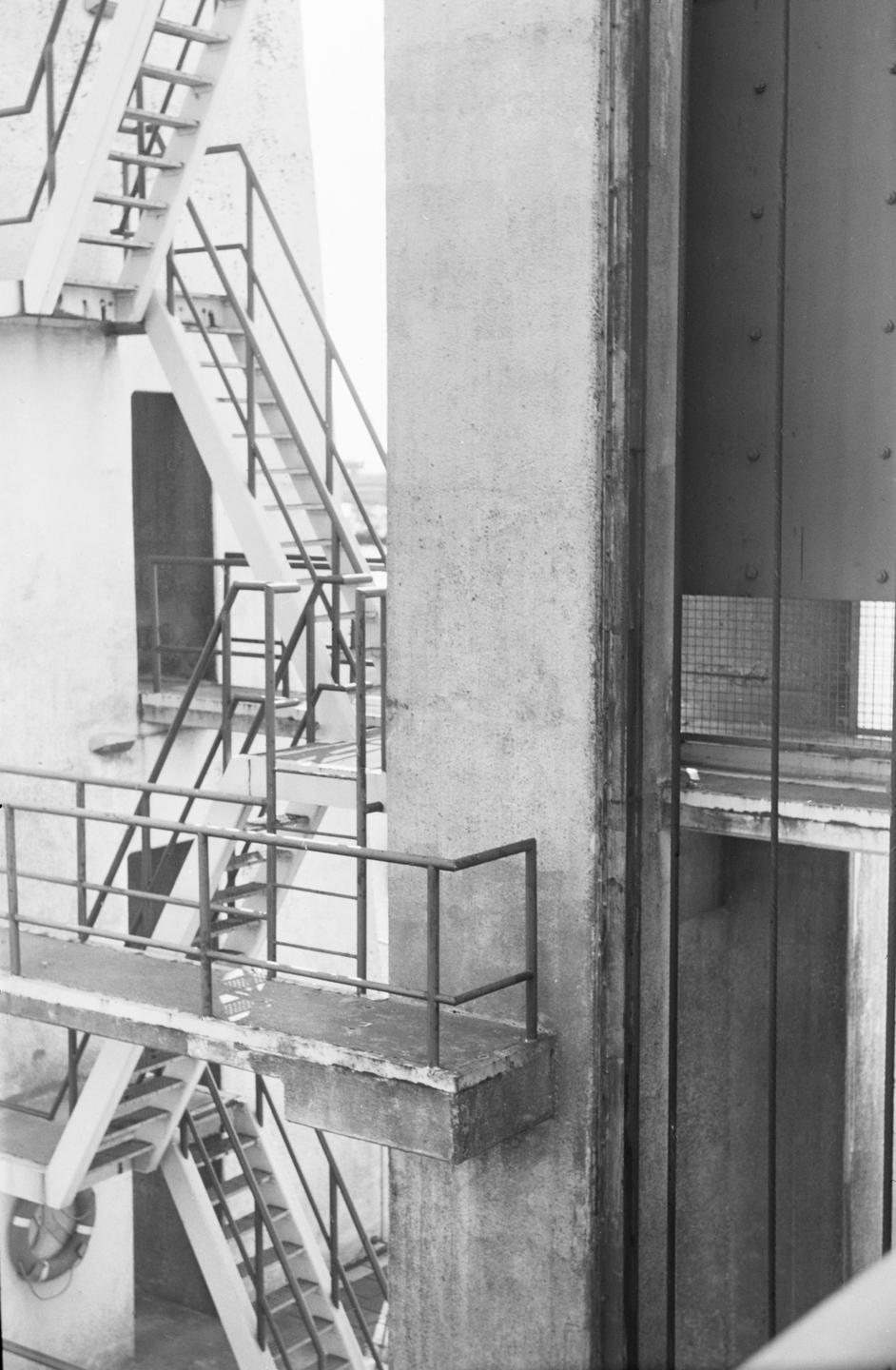 Multiple staircases and railings are visible on the side of a concrete structure.