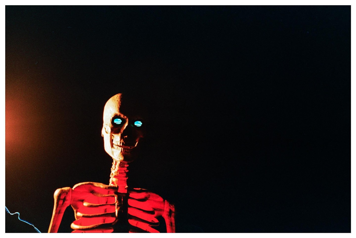 A skeleton with glowing blue eyes and a red ribcage is visible against a dark background.