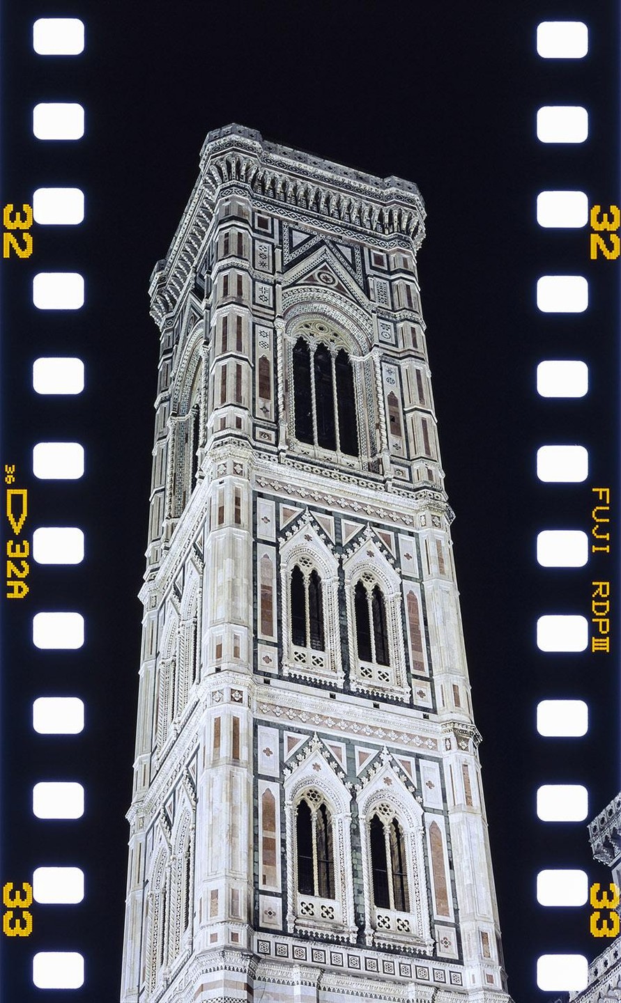 The Campanile di Giotto bell tower is illuminated at night against a dark sky.