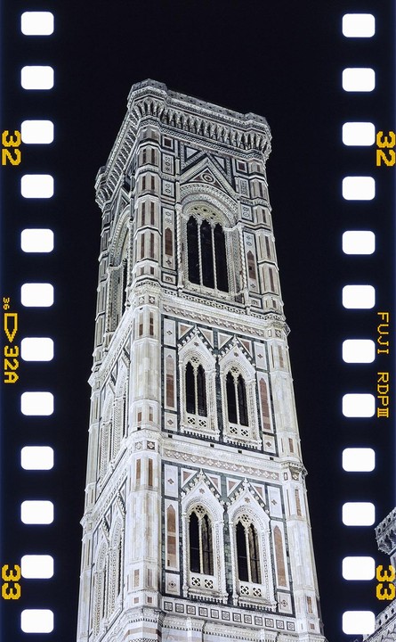 The Campanile di Giotto bell tower is illuminated at night against a dark sky.