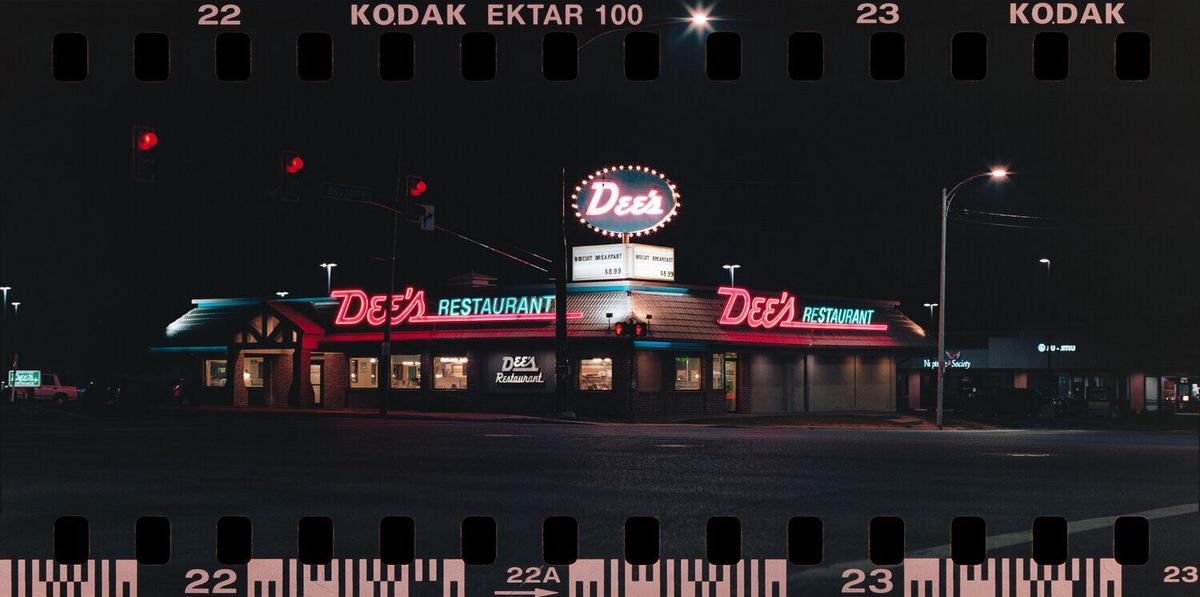 A restaurant with neon signs is illuminated at night.