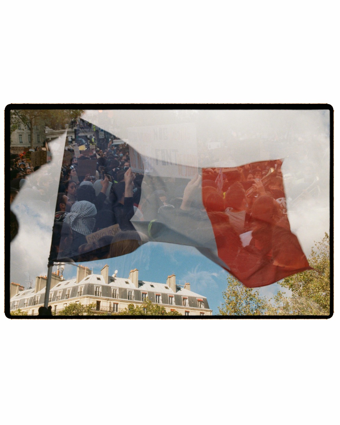 A double exposure shows a French flag waving over a building and a crowd of people protesting.