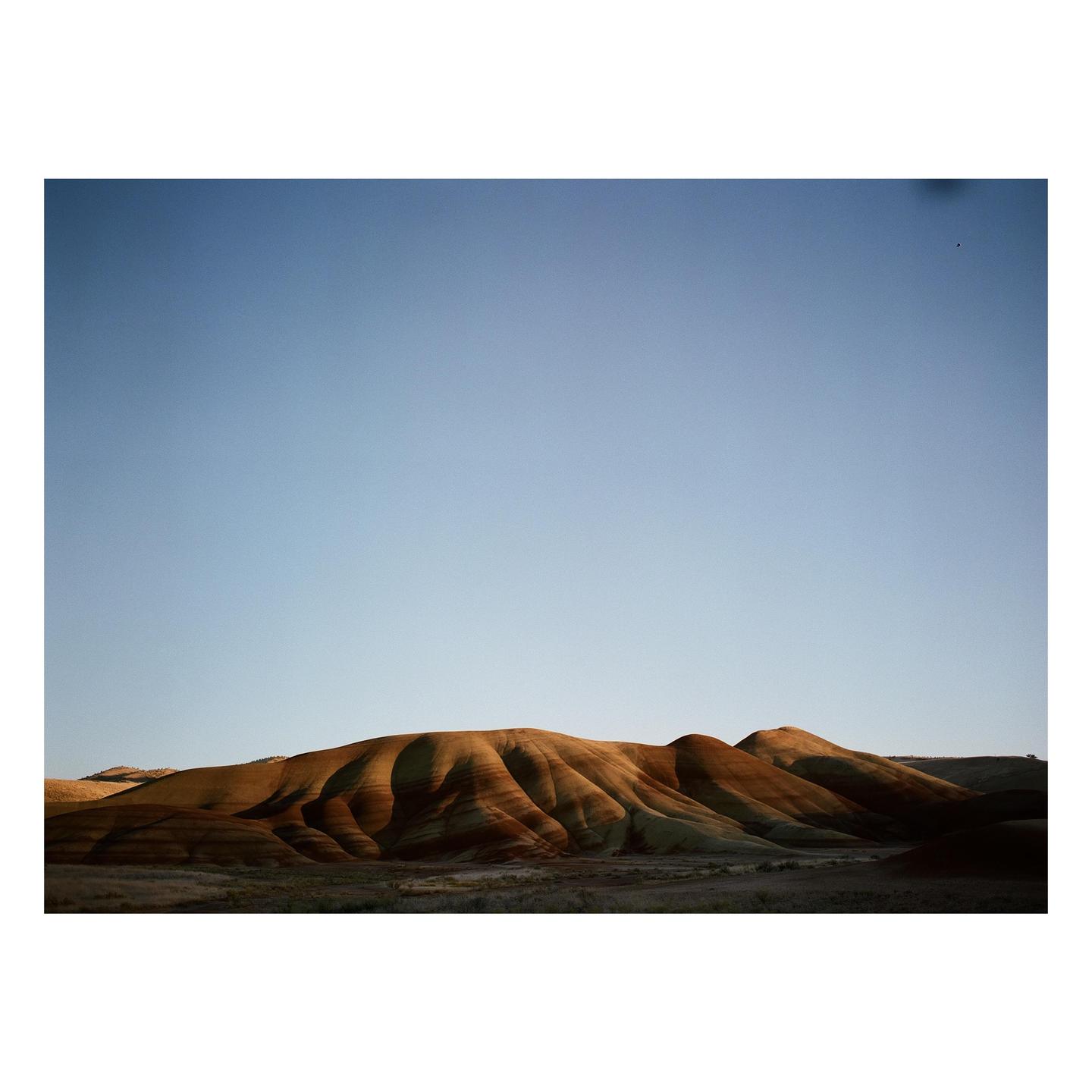 The Painted Hills are visible under a clear sky.